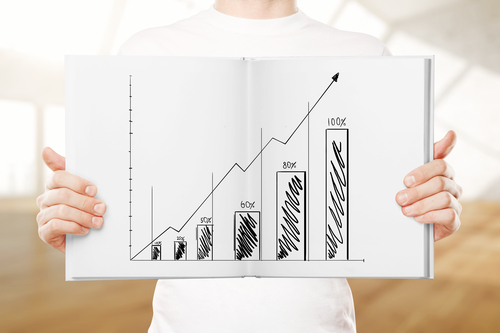 Male hands holding open book with business chart on blurry background with daylight